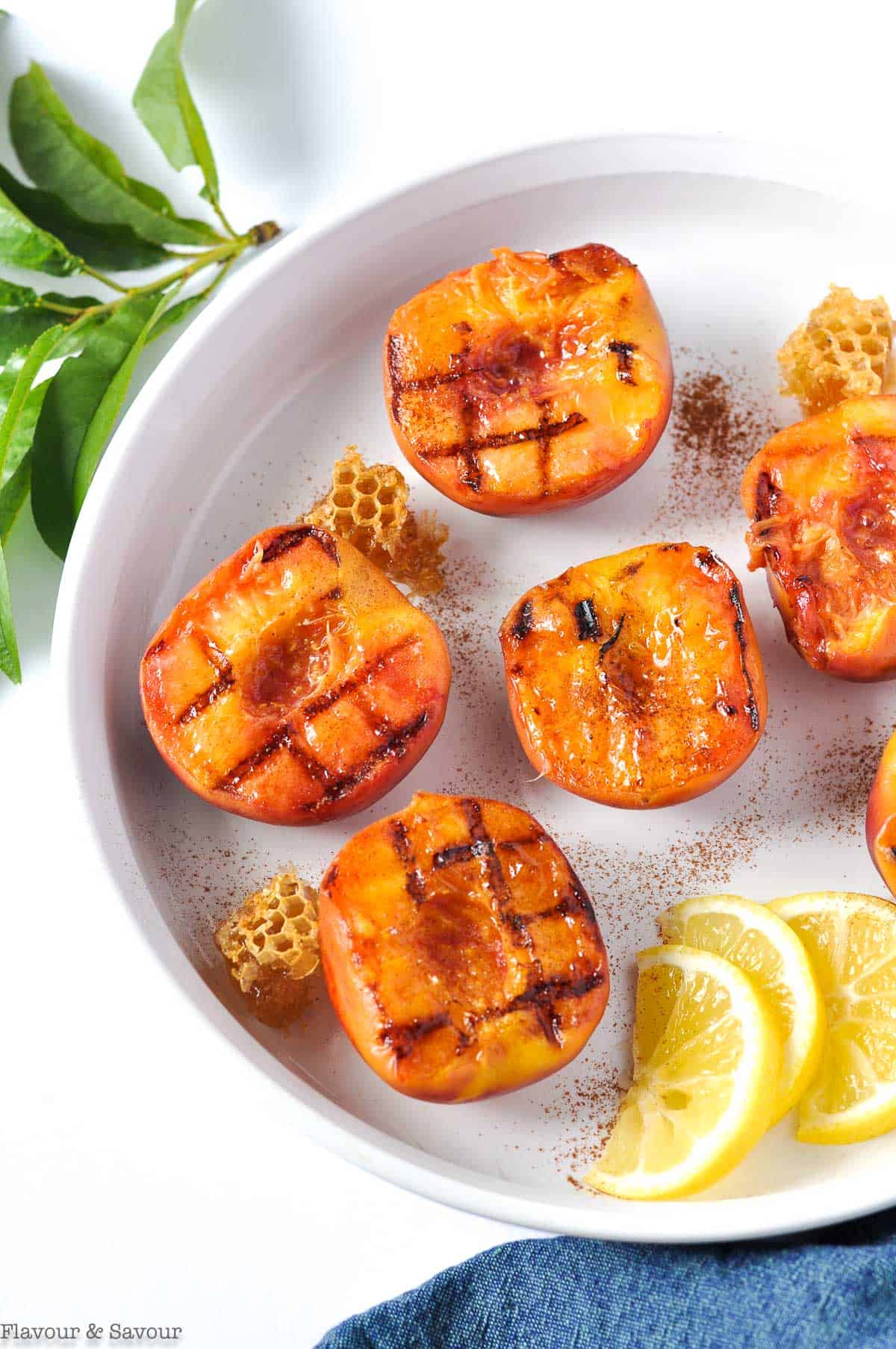 Peach halves with grill marks and lemon slices.