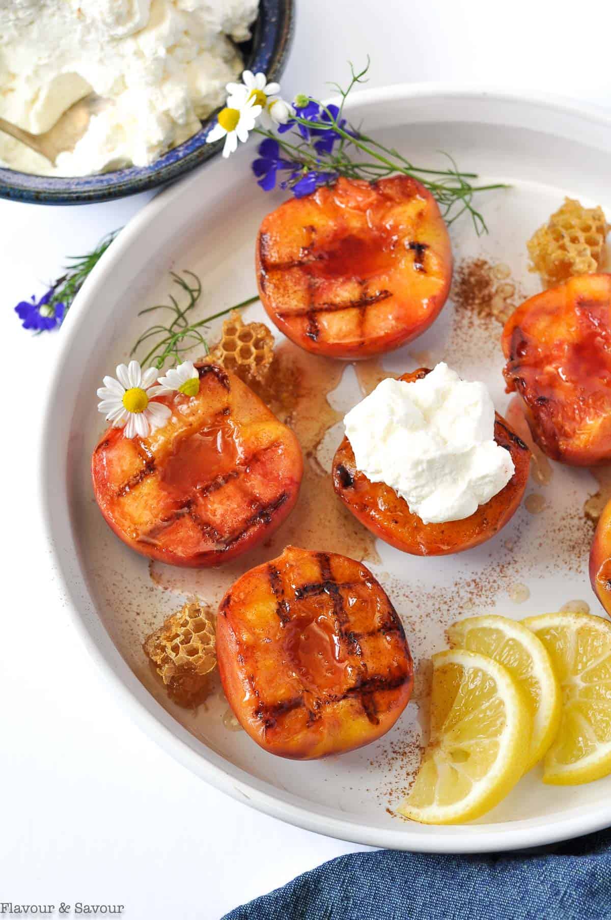 Grilled Peaches with Honey Lemon Drizzle with small pieces of honeycomb and lemon slices