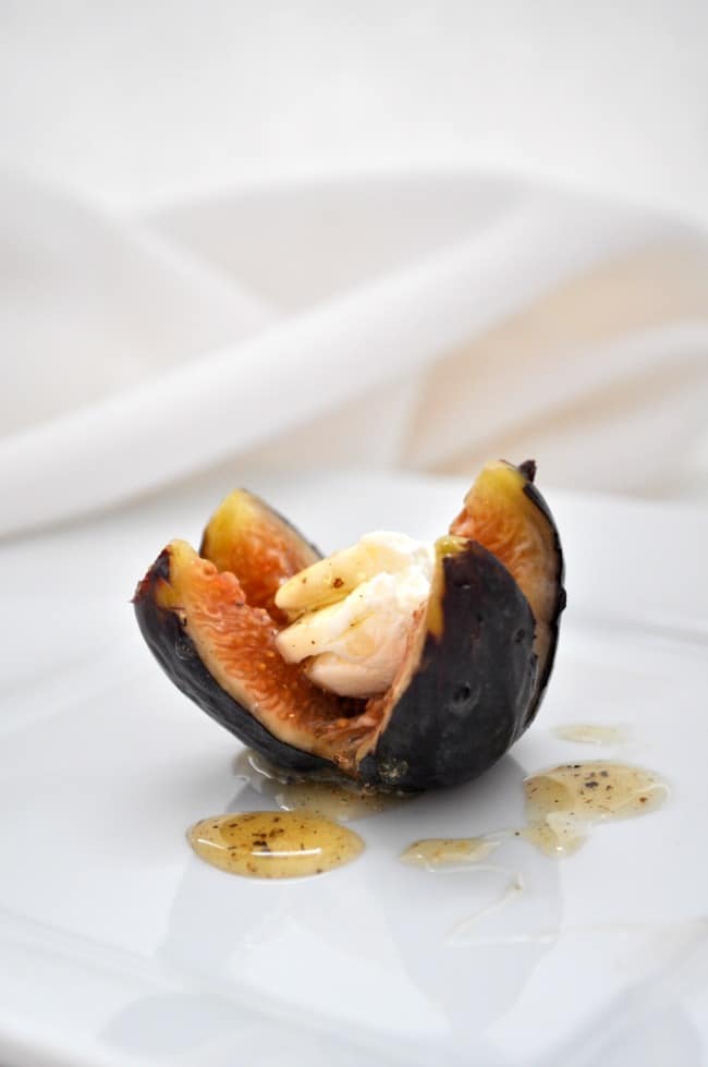 a single fresh fig stuffed with goat cheese and drizzled with honey. 