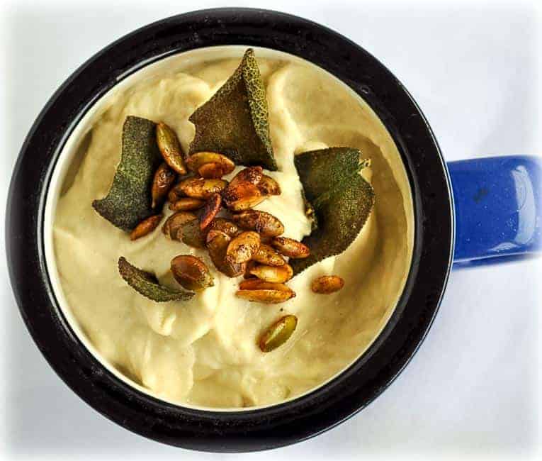 Roasted Cauliflower Soup with Spicy Pumpkin Seeds in a blue mug