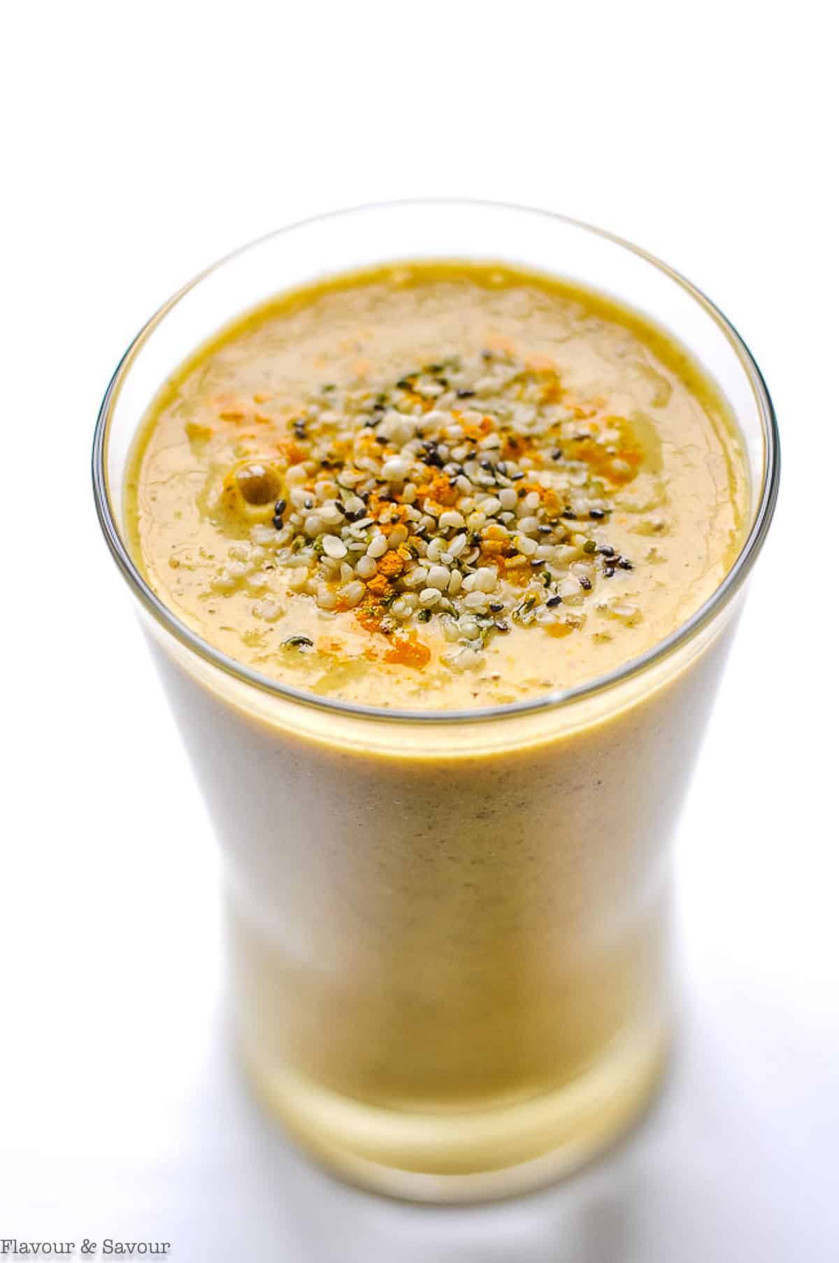 tropical turmeric smoothie in a glass with hemp and chia seeds