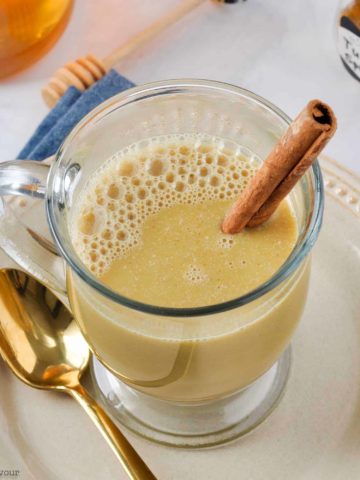 Warm Turmeric Cinnamon Milk with a cinnamon stick