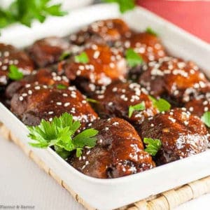 a white serving dish with Slow Cooker Sticky Chicken thighs