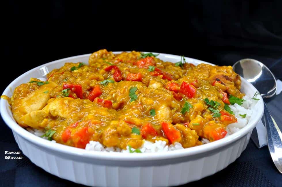 A white round shallow serving dish filled with Mango Chicken on white rice.