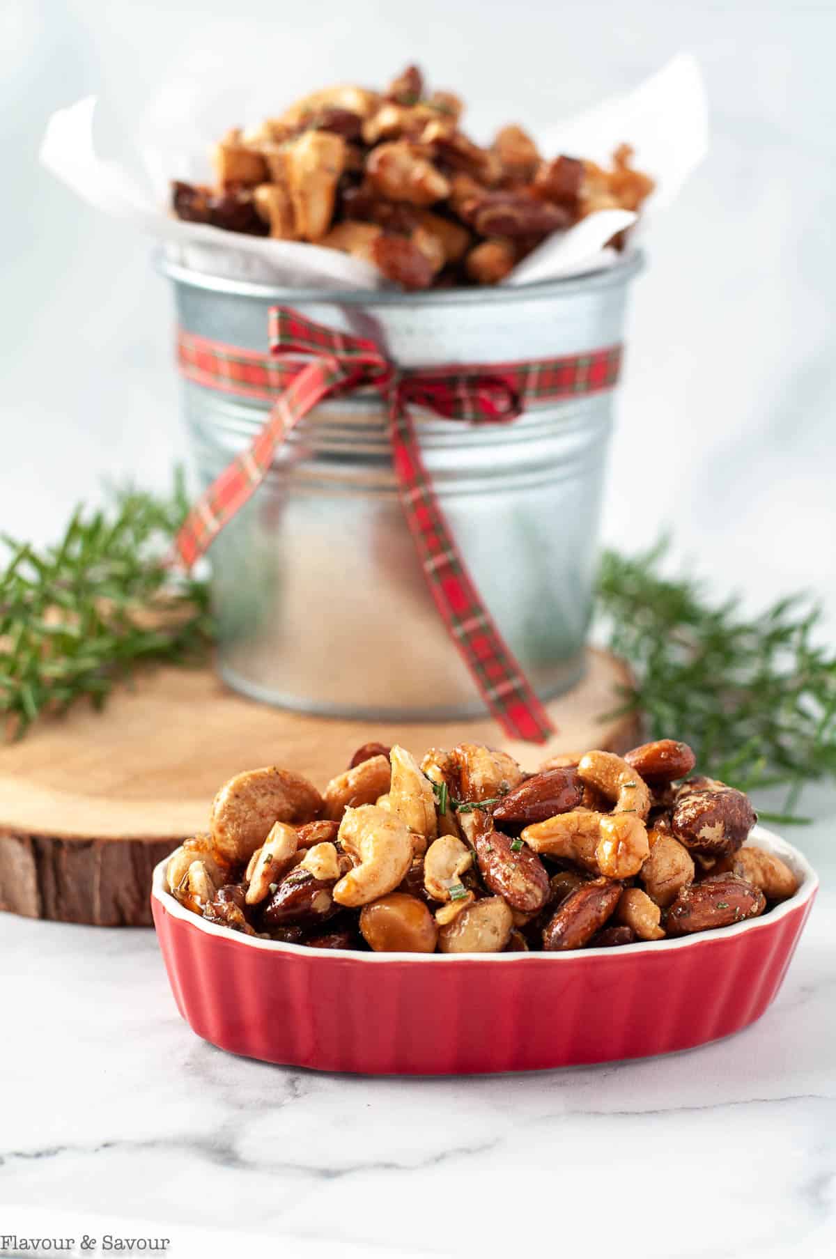 Sweet and spicy rosemary nuts in a tin and a small red bowl.