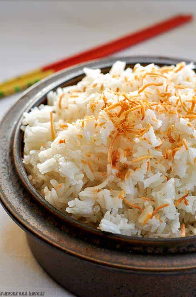 Never Fail Thai Coconut Rice in a brown stoneware bowl with chopsticks