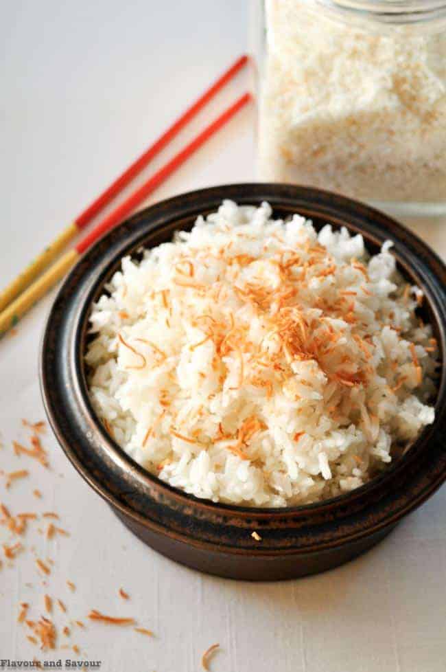 Never Fail Thai Coconut Rice with toasted coconut in a brown stoneware dish