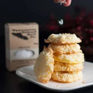 Sprinkling salt on Crispy Salted Coconut Cookies.