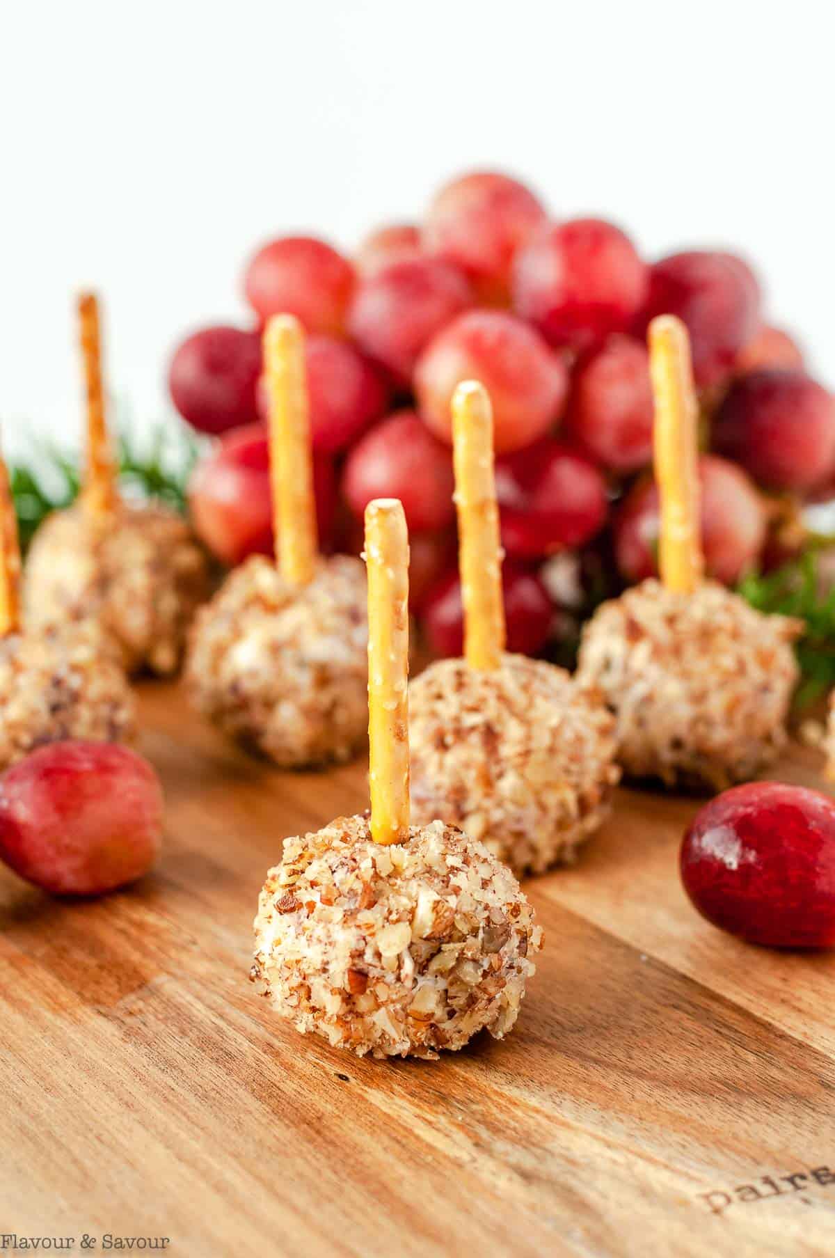 Mini Cheese Balls with pretzel sticks on a serving board