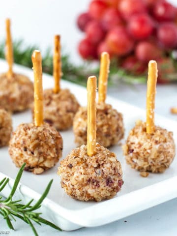 Mini Cheese Balls with pretzel sticks and grapes in the background