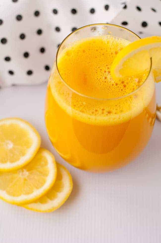 Turmeric Pick-Me-Up tonic in a glass with lemon slices