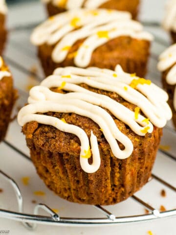 carrot ginger muffins with cream cheese glaze on a cooling rack