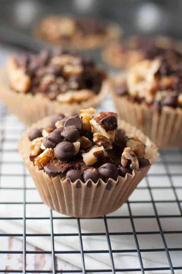 Chunky Monkey Muffins topped with walnuts and chocolate chips on a cooling rack.