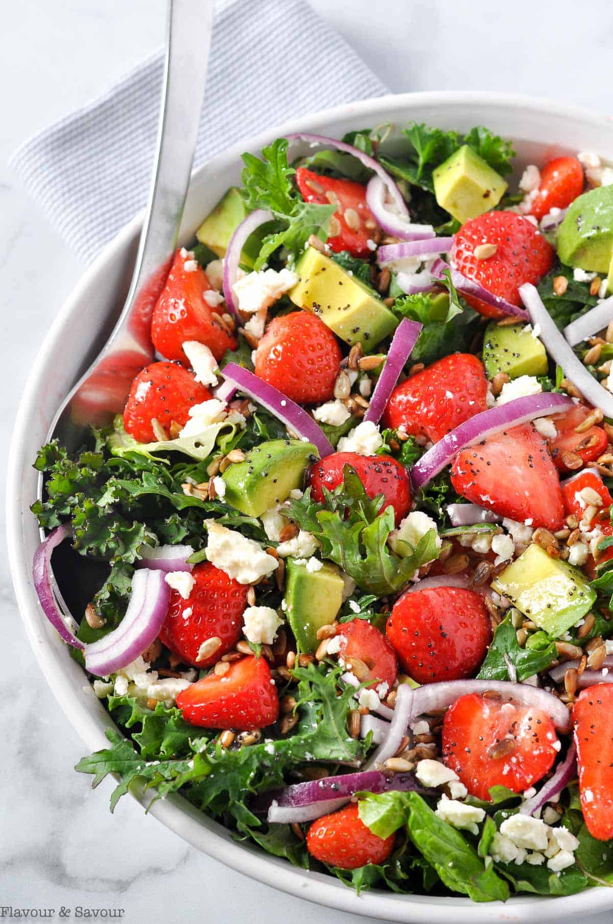 Strawberry Kale Salad with feta, avocado, red onion and toasted sunflower seeds.