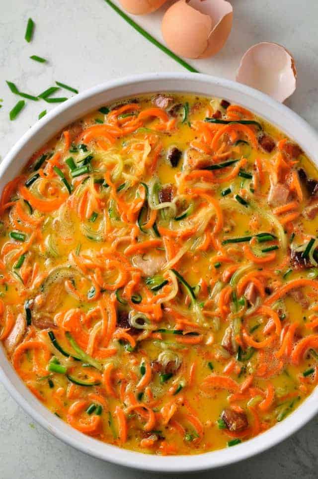 Zucchini Carrot Paleo Quiche with Bacon in a dish, ready to bake.