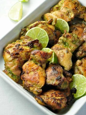 Easy Thai Baked Chicken in a serving dish with lime slices