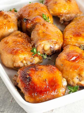 9 Maple Garlic Glazed Chicken thighs on a square white dish
