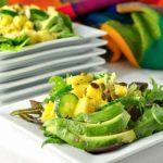 Pineapple Jicama Salad arranged on a square white plate with avocado slices
