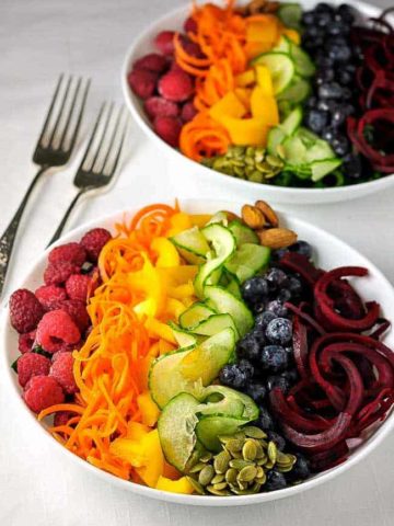 Rainbow Detox Salad. A rainbow or fruits and vegetables cut with a spiralizer and lined up in the colours of the rainbow in a bowl.