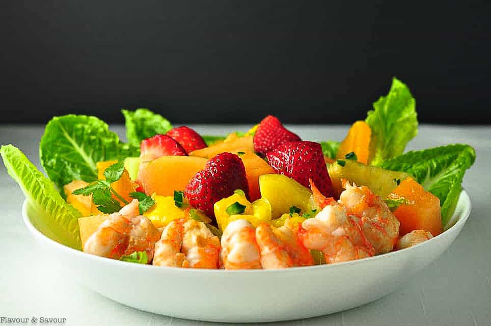 Southwestern Prawn and Fruit Salad in a white shallow bowl with strawberries, melon and mango