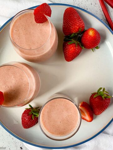 overhead view of 3 glasses of strawberry rhubarb smoothie