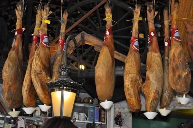 Iberico ham hanging from ceiling in a tapas bar in Seville