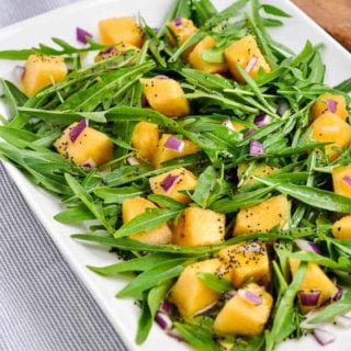Cantaloupe Arugula Salad on a white platter
