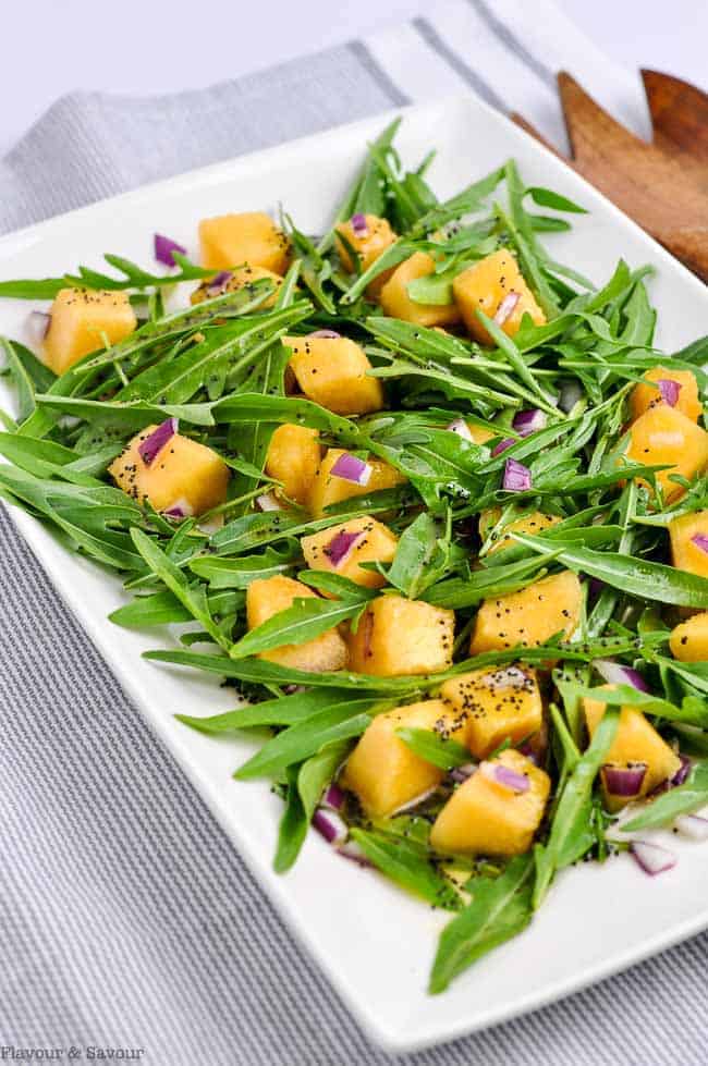 Cantaloupe Arugula Salad on a white platter