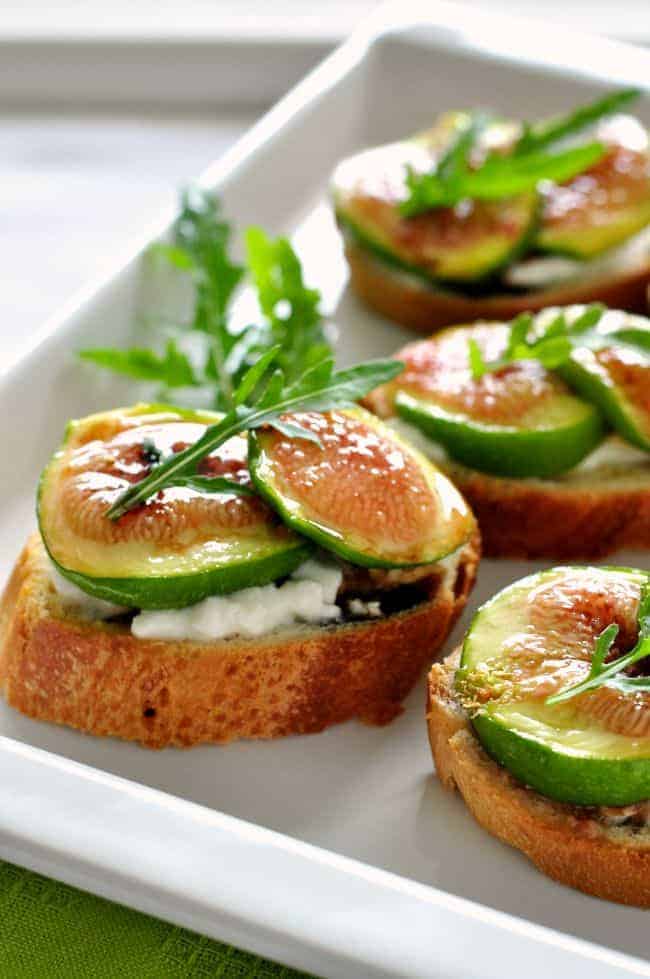 Honey roasted fig and burrata crostini with arugula leaves