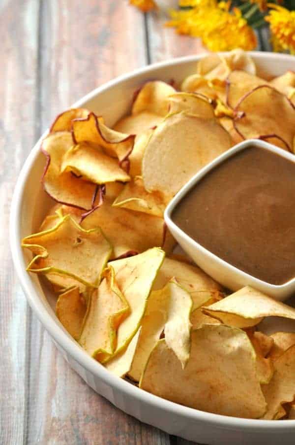 Salted Caramel Sauce in a bowl surrounded by dried apple chips