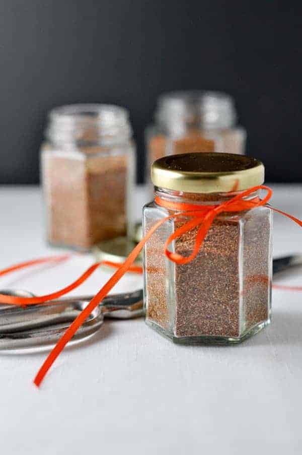 Homemade Taco Seasoning Mix in small glass jars decorated with orange ribbon.