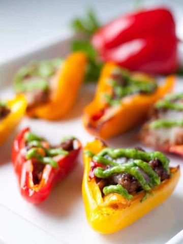 Taco Stuffed Mini Peppers. Little bites filled with taco meat and cheese and topped with avocado cream. Game-Day snack!