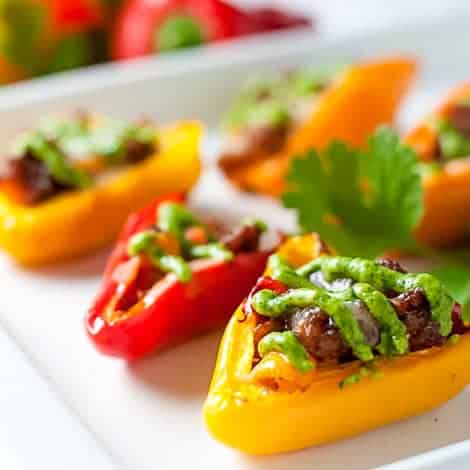 Taco Stuffed Mini Peppers. These easy appetizers make a kid-friendly snack too. Stuffed with taco-seasoned meat and topped with avocado cream.