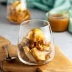 a dessert glass with apple crisp, ice cream and salted caramel bourbon sauce