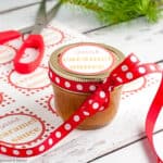 A jar of caramel sauce with a label and a ribbon.