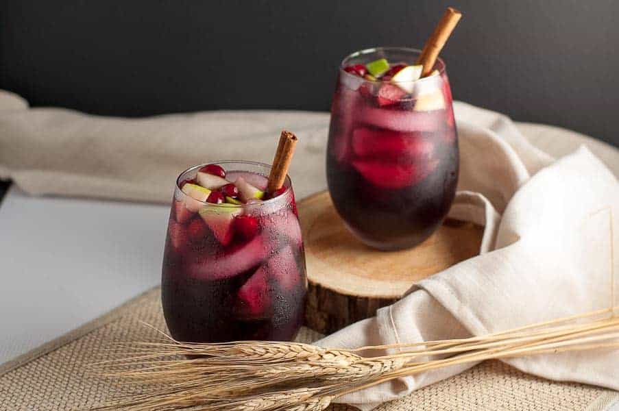 Super simple Cranberry Apple Cider Sangria garnished with cranberries, apples and a cinnamon stick