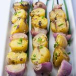 Grilled Lemon Garlic Potato Kabobs with red onions on skewers.