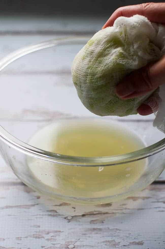 squeezing excess water from grated kohlrabi in a cheesecloth bag