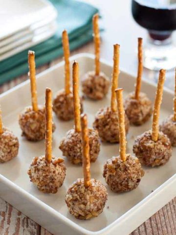 Mini Goat Cheese Balls on a Stick. Holiday party food for any time of the year. Tiny bites of goat cheese, pecorino cheese, dried cranberries and pecans, skewered with a pretzel. |www.flavourandsavour.com