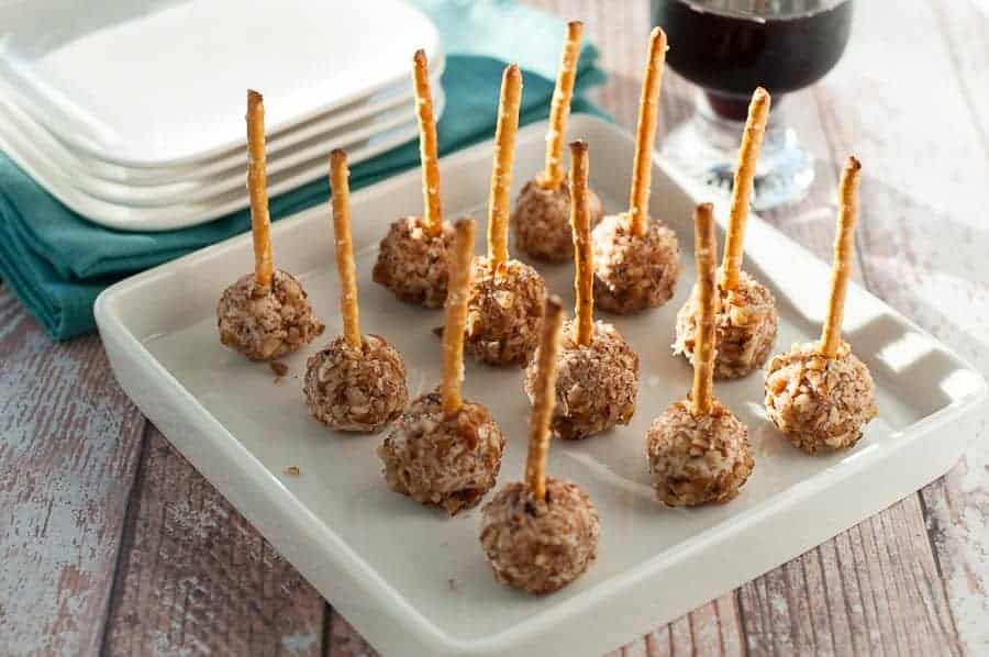 MIni Goat Cheese Balls skewered with a pretzel. Perfect party food for any season. Goat cheese, Pecorino cheese, cranberries and pecans. These disappear quickly! |www.flavourandsavour.com