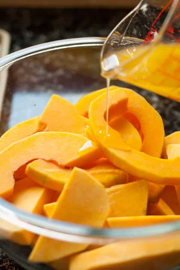 Pouring glaze on to a bowl of Butternut Squash with Fresh Rosemary and Honey-Lime Glaze |www.flavourandsavour.com