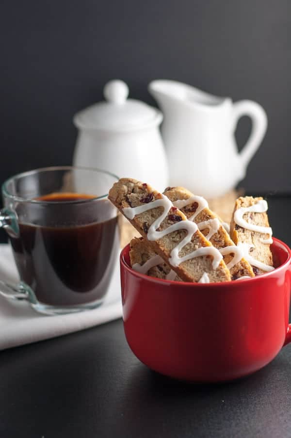 Never-Fail Cranberry Pecan Biscotti slice with a cup of coffee.