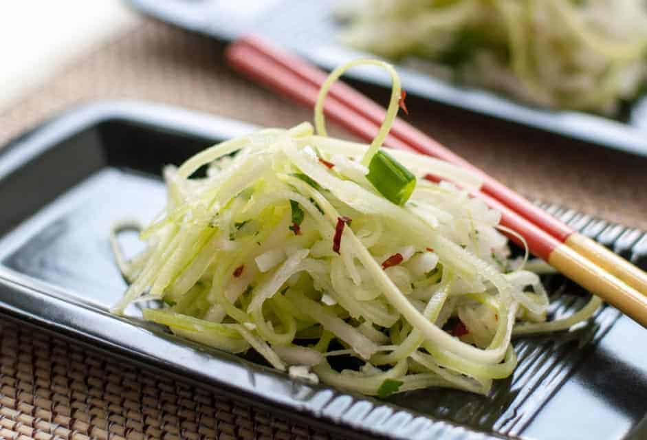 Paleo Asian Pear Slaw with Ginger and Lime on a black plate with chopsticks.