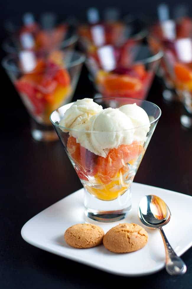 Citrus fruit cup in a glass bowl topped with gelato and amaretti cookies