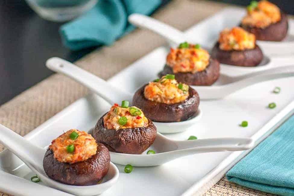 Smoked Salmon and Goat Cheese Stuffed Mushrooms in white porcelain spoons.