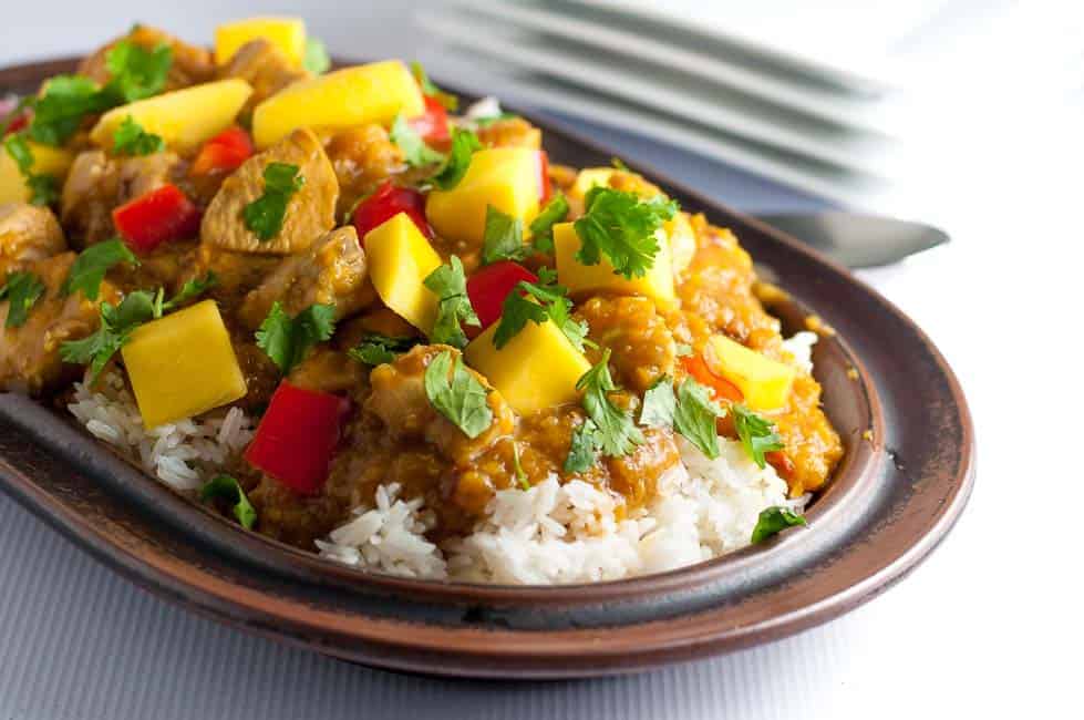 Thai Mango Chicken on rice on a brown stoneware platter.