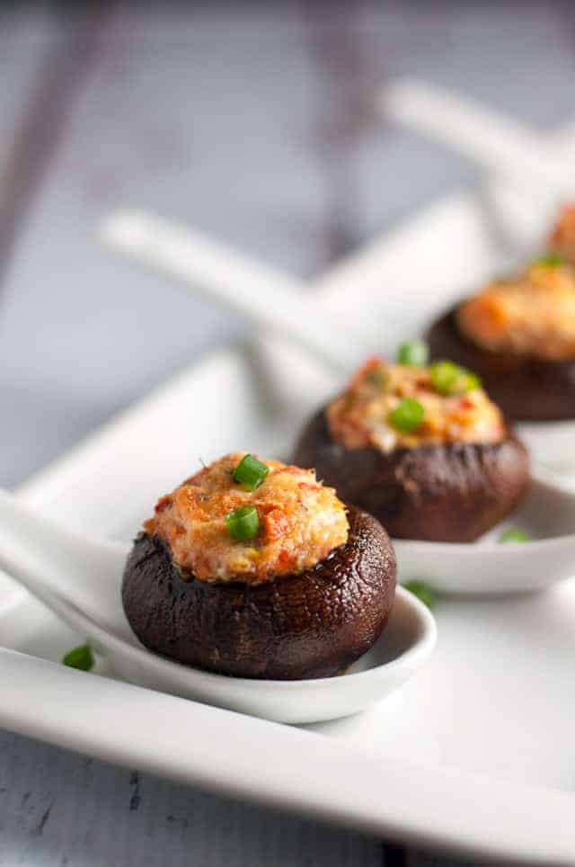 Smoked Salmon and Goat Cheese Stuffed Mushrooms in white porcelain spoons