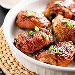 Chipotle honey-mustard glazed chicken thighs in a round white serving dish.