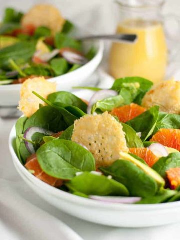 Orange and Avocado Salad with Parmesan Crisps. Sweet Cara Cara oranges, creamy avocados, fennel and red onion on a bed of fresh greens, garnished with crunch Parmesan crisps.