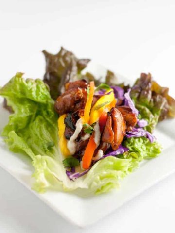 Thai Chicken Lettuce Wraps with Cashew Cream. Sweet and spicy chicken, peppers, mango, and crunchy cabbage all drizzled with a flavourful cashew cream makes a super dairy-free, gluten-free lunch or light dinner.